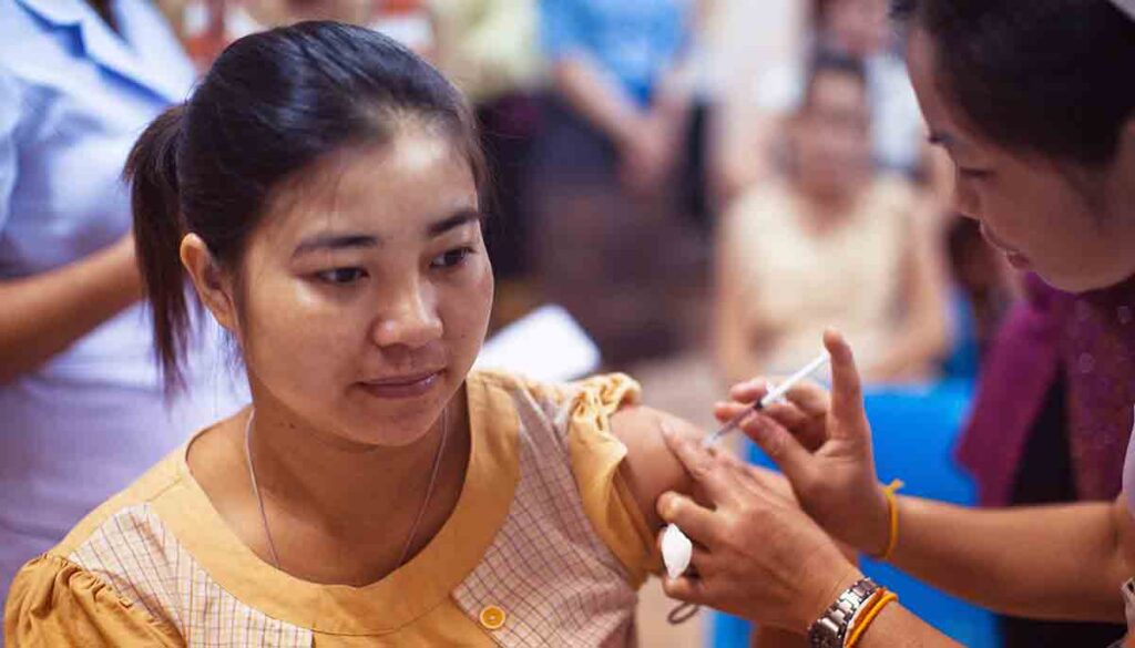 Female clinician providing a vaccine to a female patient
