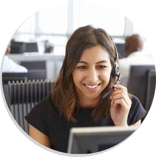 Smiling female VRI interpreter wearing a headset and looking at a computer screen