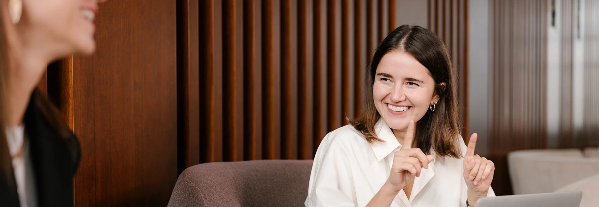 A happy ASL interpreter signs a conversation for a business meeting.