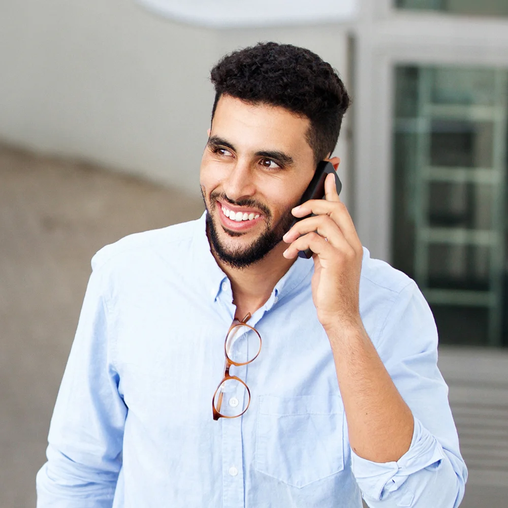 A smiling language access manager calls CLI to set up telephone interpreting services.