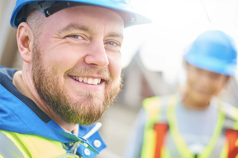 A utility worker smiles after speaking with an interpreter to have some job specifications clarified.