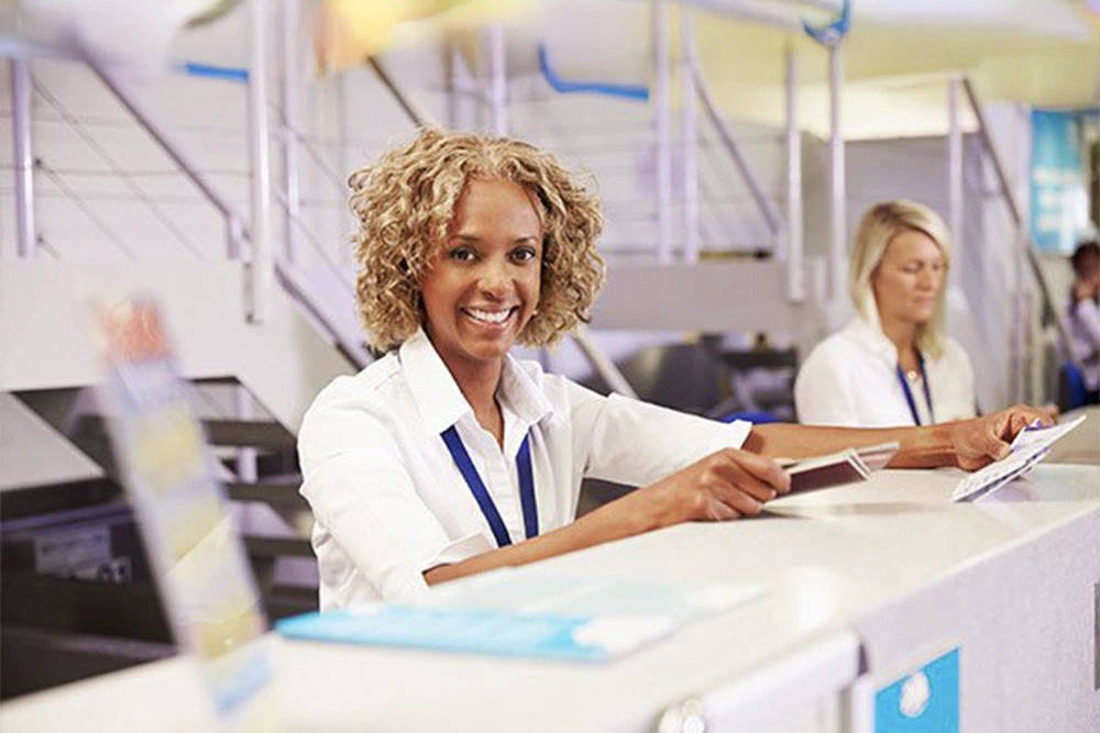 An airline ticket agent calls an interpreter to help an international traveler with their flight details.