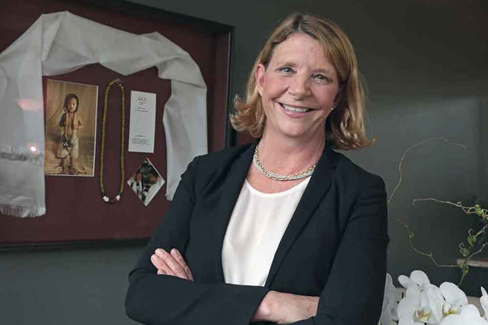 CLI CEO Kristin Quinlan smiles next to a framed gift from one of her global advocacy ventures.