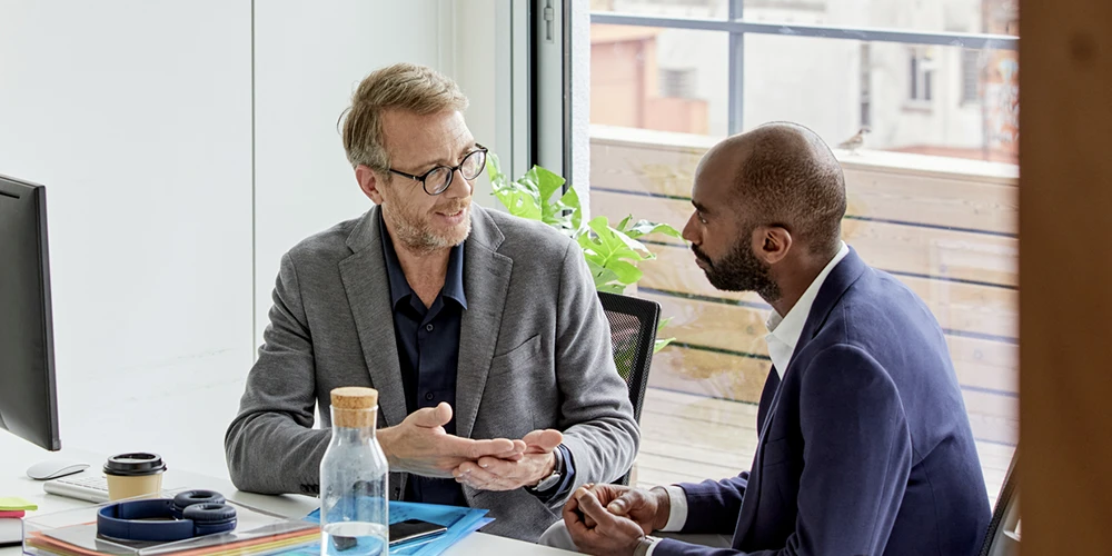 An attorney and client discuss their case, communicating through a court-certified interpreter over the phone.