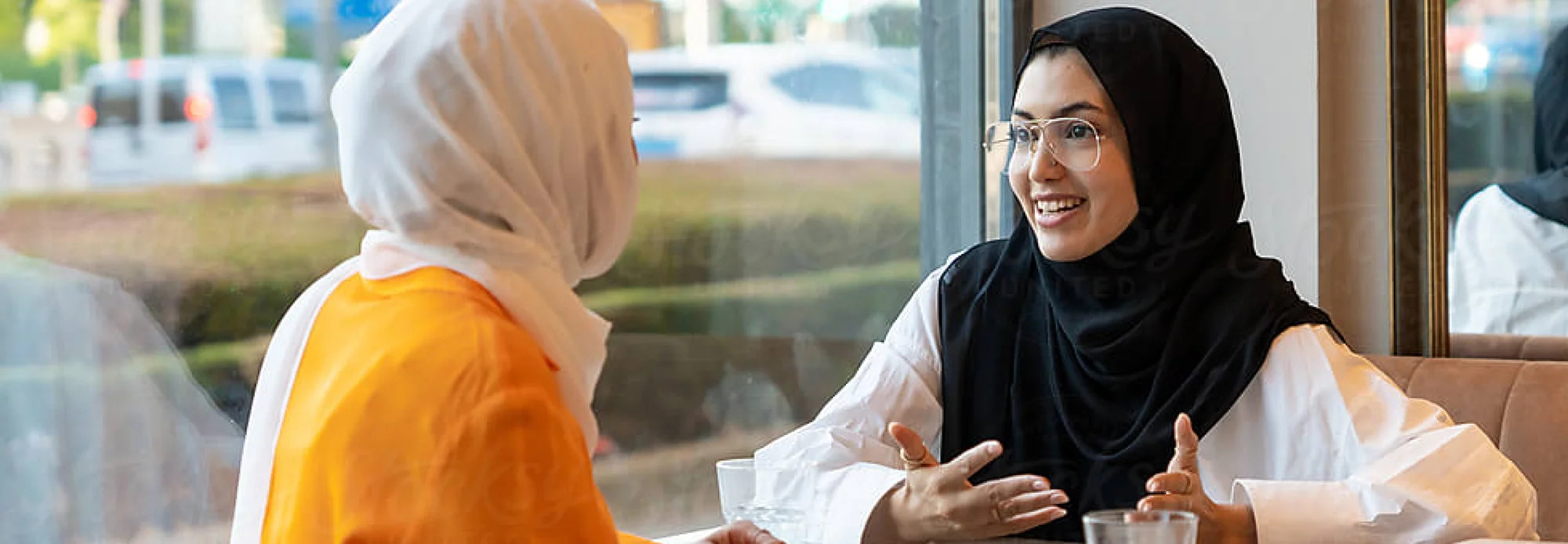 Two excited employees discuss their new bilingual roles after verifying their skills through CLI's proficiency assessment.