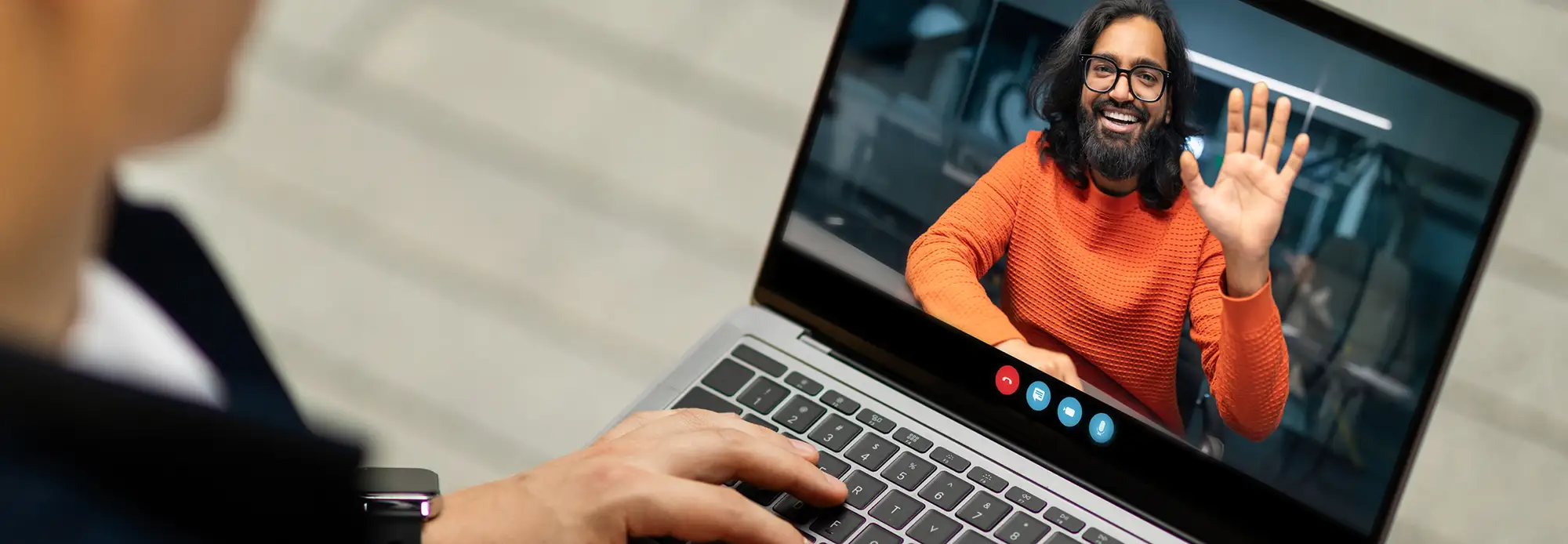 A beaming video remote interpreter waves to a caller through the computer.