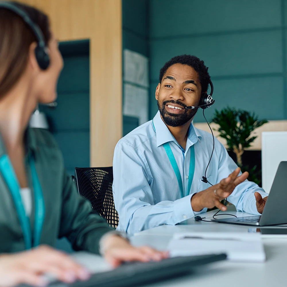 Two customer service agents discuss how many clients they helped by communicating through interpreters.