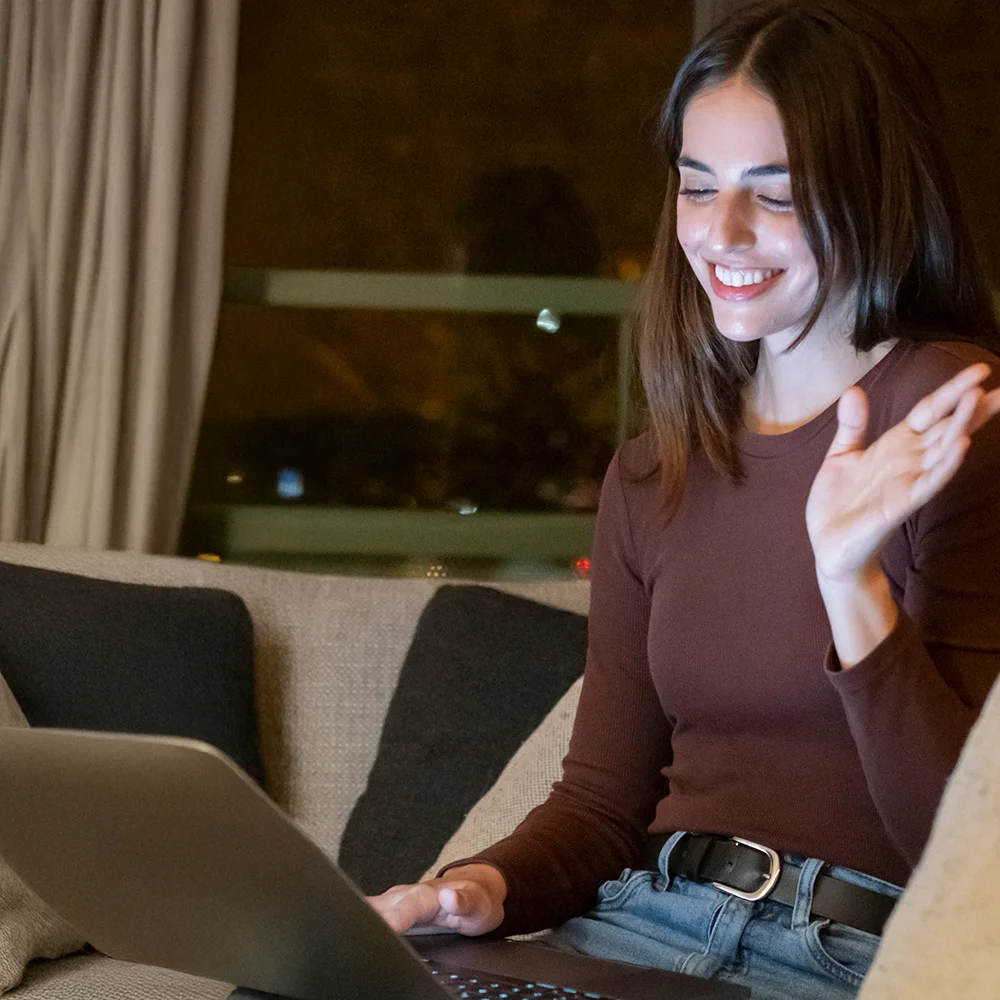 A manager waves to their webcam upon being quickly connected to an interpreter via video call.
